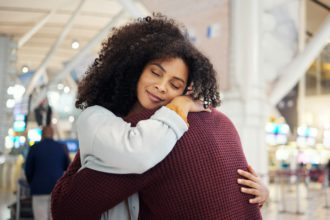 Couple, hug and smile in goodbye at airport for travel, trip or flight in farewell for long distanc