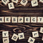flat lay with arranged wooden blocks in respect word on brown wooden surface