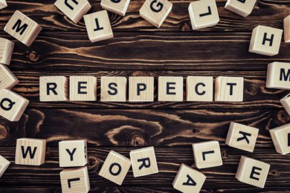 flat lay with arranged wooden blocks in respect word on brown wooden surface