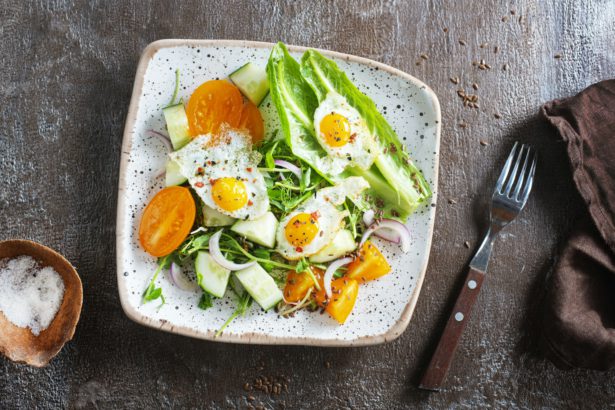 fried eggs with vegetables, top view, diet salad with quail eggs