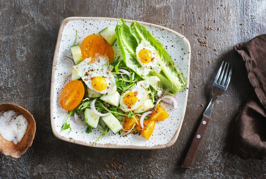 fried eggs with vegetables, top view, diet salad with quail eggs